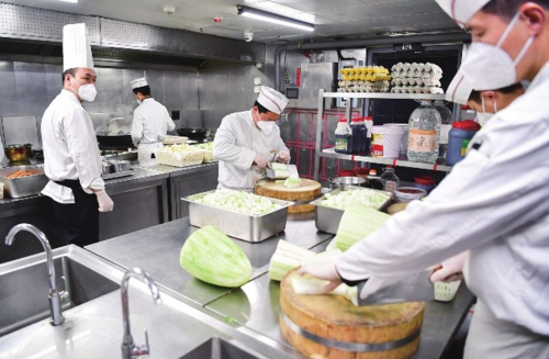 图为在位于陕西省西安市曲江新区的西安饭庄大唐不夜城店内，厨师在制作餐食。新华社