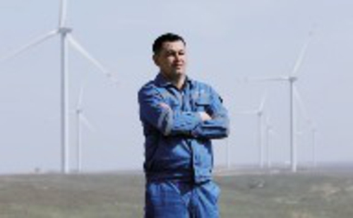     在哈萨克斯坦札纳塔斯，阿比尔加济耶夫站在风电项目风机前。新华社