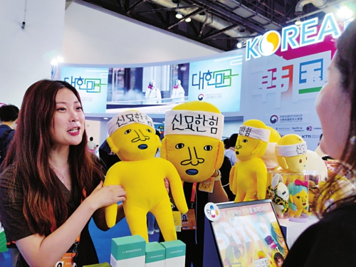 9月2日,国家会议中心韩国展区,希杰集团中国区总部MKT部门工作人员向参观者介绍韩国综艺节目《新西游记》里的角色布偶。