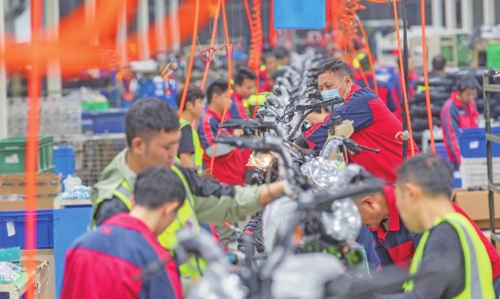 11月13日,在位于重庆高新区的重庆鑫源摩托车股份有限公司工厂内,工作人员在生产线上组装出口至拉美国家的摩托车。新华社